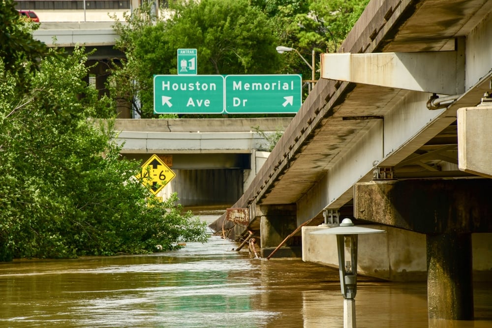 Buffalo,Bayou,Park,Houston,,Flooded,After,Hurricane,Beryl Flooded urban street under a highway overpass with green signs reading Houston Ave and Memorial Dr above the water.