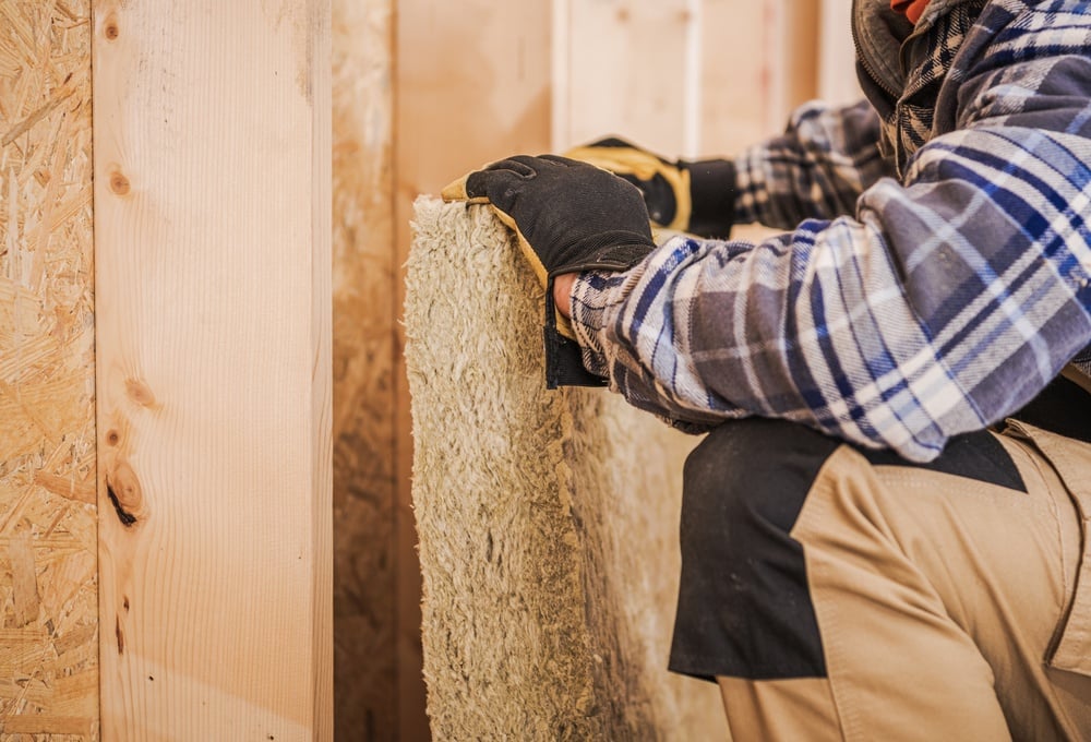 A,Person,Cuts,Insulation,Material,To,Fit,Into,A,Wall